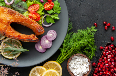 Plato con salmón, verduras frescas y hierbas, representando una dieta antiinflamatoria para la salud y el bienestar