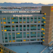 Joven profesional de la salud de pie en un pasillo hospitalario, representando talento médico emergente en UMC.