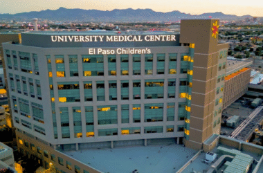Joven profesional de la salud de pie en un pasillo hospitalario, representando talento médico emergente en UMC.