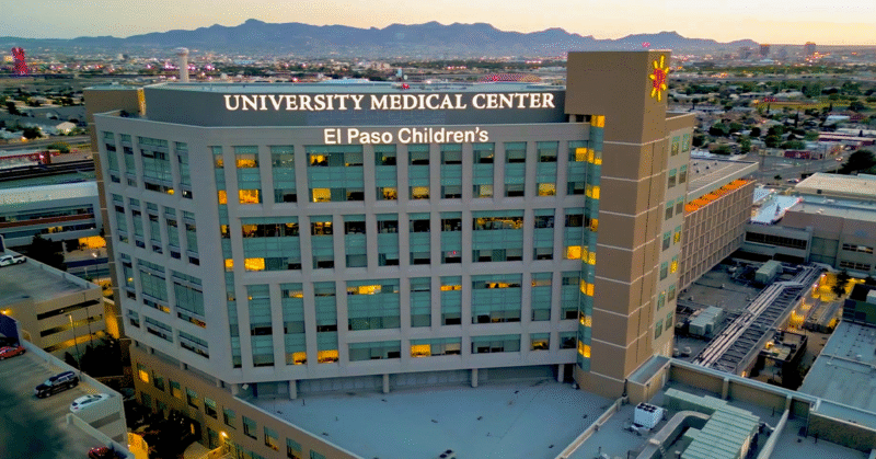 Joven profesional de la salud de pie en un pasillo hospitalario, representando talento médico emergente en UMC.