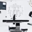 Quirófano moderno equipado con tecnología robótica avanzada, que cuenta con múltiples brazos robóticos articulados y pantallas de computadora, creando un entorno de alta tecnología, moderno e innovador.