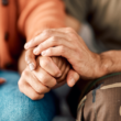 Dos personas tomándose de las manos, representando apoyo y salud mental.