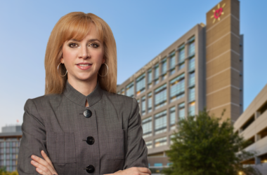 María Zampini, nueva directora ejecutiva de UMC, parada frente a un edificio de UMC El Paso.