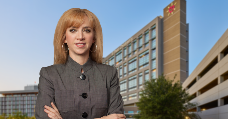 María Zampini, nueva directora ejecutiva de UMC, parada frente a un edificio de UMC El Paso.