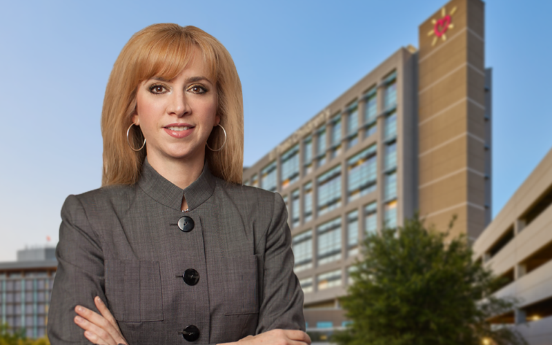 María Zampini, nueva directora ejecutiva de UMC, parada frente a un edificio de UMC El Paso.