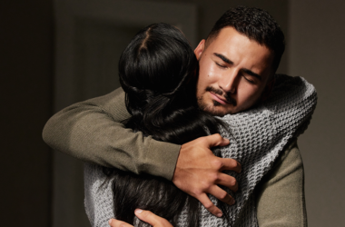 Un hombre y una mujer compartiendo un abrazo reconfortante, ofreciendo soporte emocional, representando concientización sobre las sobredosis.