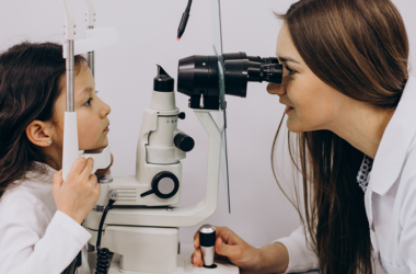 Una oculista examina los ojos de una niña pequeña, durante un examen de la vista.