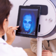 Una dermatóloga revisando la piel de una persona a través de una máquina de análisis facial.