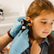 Un profesional de la salud realiza un chequeo auditivo en una niña.