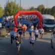 Personas corriendo a través de un arco durante una carrera comunitaria de 5 km.